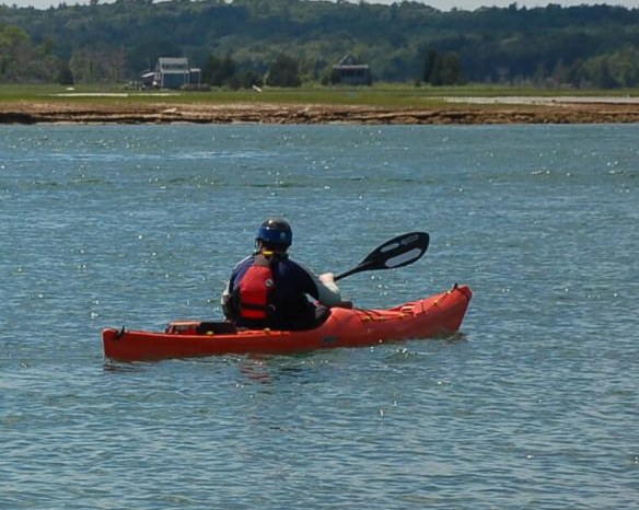 Paddler heading out at golden hour along the shoreline